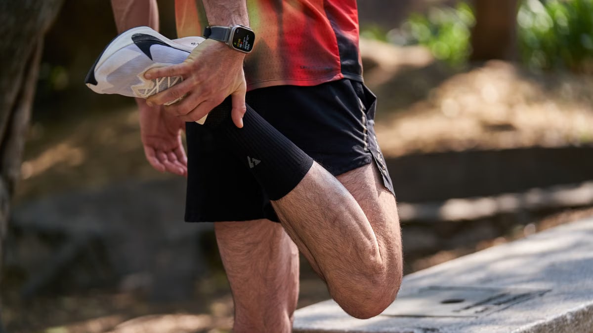 An athlete performs a stretching routine outdoors, highlighting fitness and healthy lifestyle.
